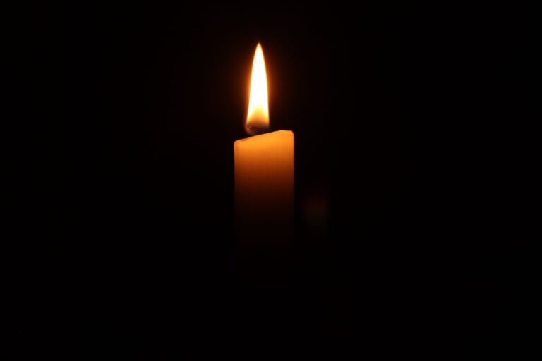A single candle burning softly in a dark room